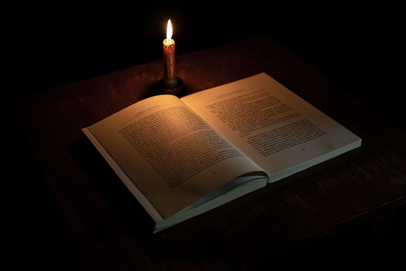 An open book read by candlelight